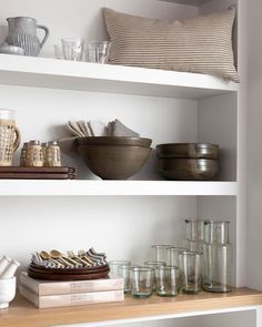 the shelves are filled with dishes and glasses