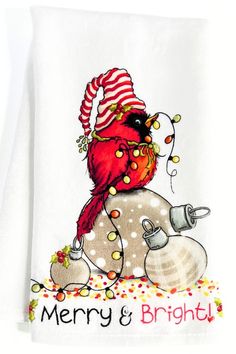 a white dish towel with a red bird on it's head and merry and bright lights