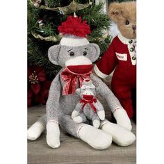 two stuffed animals sitting next to each other in front of a christmas tree with presents