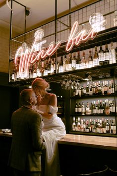 a man and woman standing in front of a bar