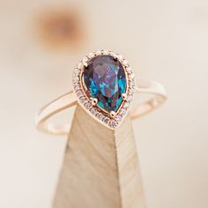 a ring with a large blue stone surrounded by small white and brown diamonds on top