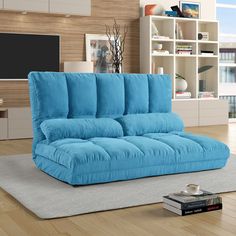 a blue couch sitting on top of a rug in a living room next to a tv