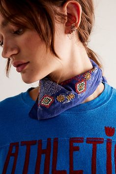 a woman wearing a blue shirt with the word athletic on it's chest and a bandana around her neck