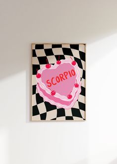 a pink heart with the word scorppo on it hanging from a wall