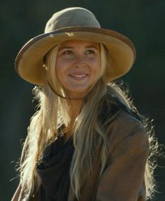 a woman wearing a brown hat with long blonde hair