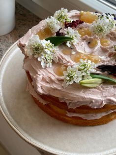 a cake with frosting and flowers is on a plate