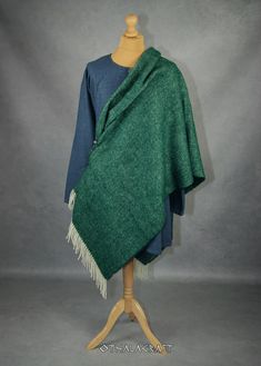 Beutifull blanket in green color, made of made of 100% wool. Can be used as cape or also as a blanket. Rectangular shape 188 cm x 142 cm (74 inch x 55,90 inch) plus 10 cm ( 3,9 in) fringe . Very soft wool and gentle for skin. This kind of capes are known from iconography in Viking age.  Coats of this type are known from iconography, runestones or amulets from the Viking Age. They are comfortable, warm, act as a coat and a blanket, which you can wrap yourself in the evening. Thrown over one shoulder, they should be fastened with a brooch or a pin.  Blanket should be washed in 30% hand washing. Silver brooch is not included. Traditional Green Winter Shawl, Woolen Blanket, Viking Garb, Woollen Blankets, Throw Over, Viking Age, Amulets, Silver Brooch, Soft Wool