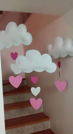 some paper hearts are floating in the air above stairs and clouds that look like they have been raining