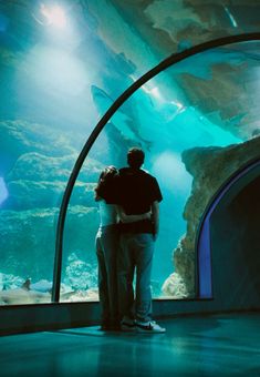 two people standing in front of an aquarium