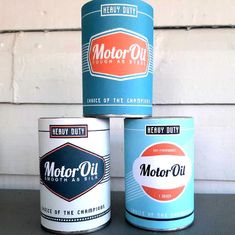 three cans of motor oil sitting next to each other