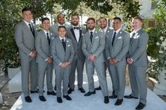 a group of men in suits standing next to each other on a white carpeted area