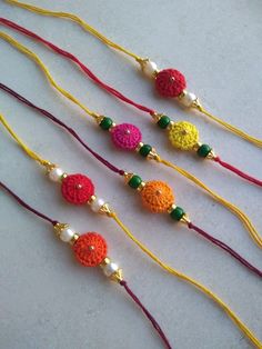 four crocheted necklaces with colorful beads and bead ends on a white surface