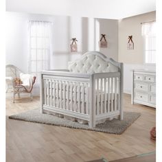 a baby crib in a room with white furniture