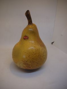 a yellow pear sitting on top of a white table