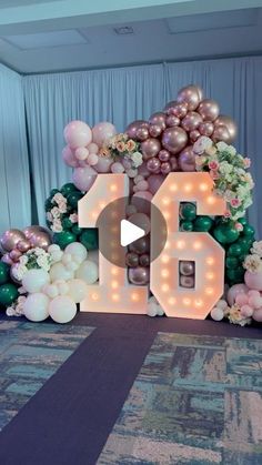 balloons and flowers are arranged around the top of a balloon arch that reads 50 cents