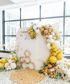 a table topped with balloons and flowers next to a white sign that says sweet as pie