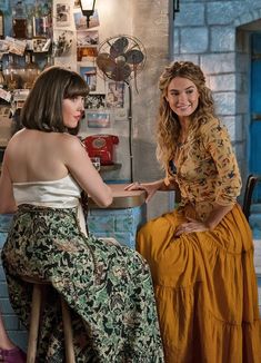 two women sitting at a table in front of a counter