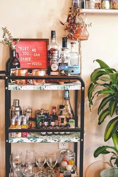 a bar cart filled with liquor bottles and glasses