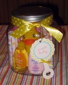 a glass jar filled with baby items on top of a table