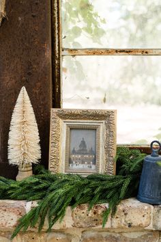 an old window sill decorated with pine cones, evergreen and a blue thimble