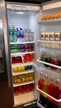 an open refrigerator filled with drinks and fruit