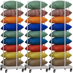 a stack of pillows sitting on top of a metal rack next to a white wall