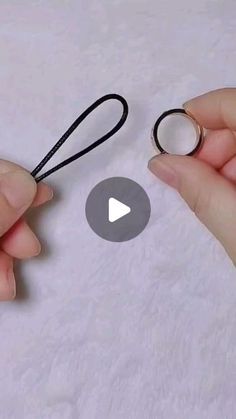 two hands are holding scissors and string on a piece of paper with the video below it