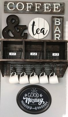 coffee and tea bar sign hanging on the wall next to two mugs with cups