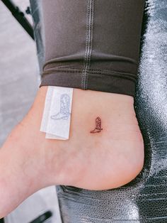 a small tattoo on the ankle of a woman's foot with a boot design