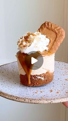 someone holding up a piece of cake with whipped cream and caramel