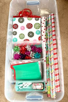 a plastic container filled with lots of different types of wrapping paper and other things in it