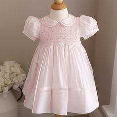 This Pink Smocked Dress In Size 12 Months By Feltman Brothers Is Super Sweet! The Traditional Style Dress Has A Peter Pan Collar With A Matching Trim That Is Hand-Sewn With Faggoted Stitching (Very High-End Feature). The Short Puffed Sleeves Have A Matching Band That Is Also Hand-Sewn With Faggoted Stitching. The Entire Bodice Is Smocked In A Lattice Design With Pink Embroidery. Sweet Little Pink And White Bullion Roses Are Hand Sewn On Top Of The Lattice Embroidery. The Bottom Of The Smocking H Pink Smocked Dress, Lattice Embroidery, Feltman Brothers, Heirloom Dresses, Scalloped Border, Pink Embroidery, Lattice Design, Smocked Dress, Perfect Baby Shower Gift