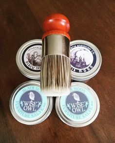 three different types of shaving brush on top of some tins that are sitting on a table