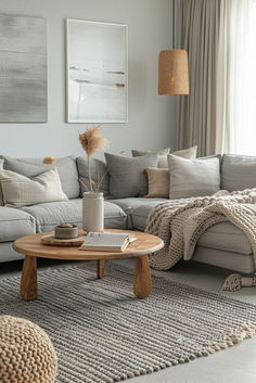 a living room filled with lots of furniture and pillows on top of a gray rug