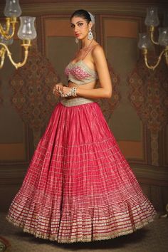 Rani pink toned attached cancan cotton simmer chanderi crinkled lehenga with stacked style striped gota wave embroidery and heavy tassel ornamentations. Paired with a noodle strap flattering sweetheart neckline padded blouse with geometric gota jaal embroidery and dori embroidered hem detail and heavily embellished floral border net dupatta with gold toned butti details. - Aza Fashions Elegant Pink Choli With Cutdana, Elegant Pink Cutdana Choli, Pink Gown With Cutdana In Saree Shape, Pink Gown With Cutdana Details In Saree Shape, Elegant Pink Choli For Diwali, Designer Pink Lehenga With Cutdana Detail, Designer Pink Lehenga With Cutdana, Pink Dori Work Gown For Wedding, Elegant Pink Gown For Navratri