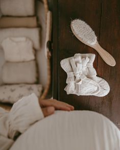 a person laying in bed with their hand on the pillow next to it and a wooden brush