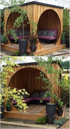 a small wooden shelter with purple cushions and pillows on the outside, surrounded by potted plants