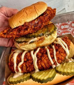 a chicken sandwich with pickles and sauce on it