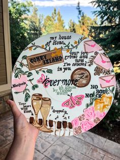 someone holding up a paper plate decorated with words and images on the outside of their house