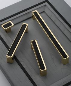 the black and gold handles are on top of the gray surface, which is surrounded by smaller square objects