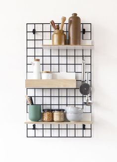 three shelves with various items on them against a white wall