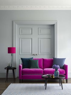 a living room filled with furniture and a pink couch