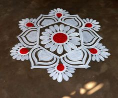 a white and red design on the ground with some red circles around it that looks like flowers