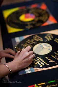 a person is writing on a record that has been placed on the table for display