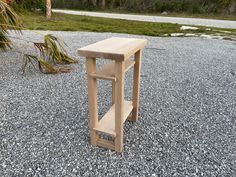 a small wooden table sitting on top of gravel