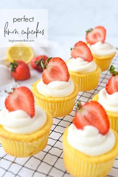 some cupcakes with strawberries on top are sitting on a cooling rack