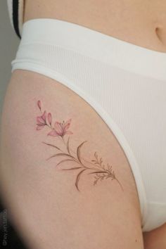 a woman's stomach with a flower tattoo on the side of her belly,