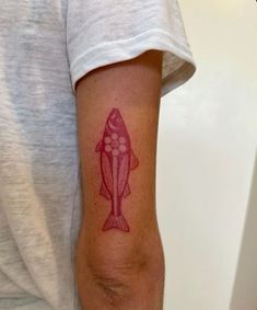 a person with a fish tattoo on their arm