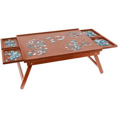 a wooden table with two trays on it and blue flowers painted on the top