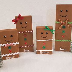 four brown paper bags with different designs on them sitting in the snow next to a christmas tree